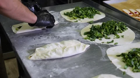 Close-up of a chef in gloves preparing tortillas with herbs, kutabs, gozleme. Stock Footage 321814608