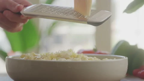 Close up of Chef Grating Fresh Parmesan Cheese over Pasta Dish in Window Light Vídeo Stock 208795400