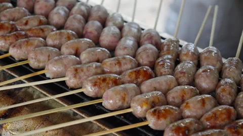 Close up chef grilling fresh meat sausages. Asian Thai street fast food Stock Footage 257922536