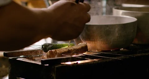 Close up of chef grilling meat on skewer in slow motion, Japan Stock Footage 124678845