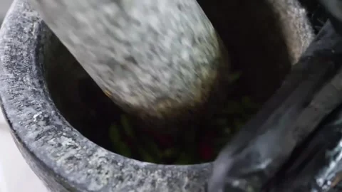 Close-up of Chef Grinding Fresh Chilies in Stone Mortar for BBQ Steak Marinade Stock Footage 338211952