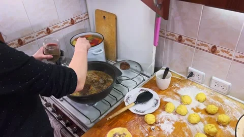 Close Up of Chef Hand Adding Spices to Kazan Pot of Shurpa Soup Stock Footage 329745344