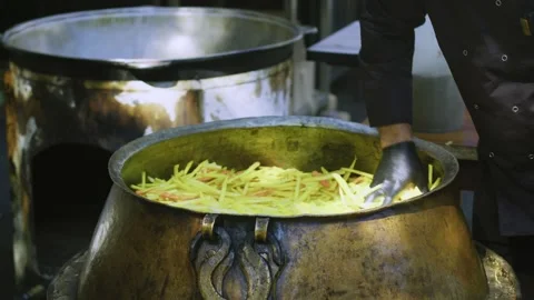 Close-Up of Chef Hand in Black Glove Spreading Sliced Carrots in Large Cauldron Stock Footage 346626958