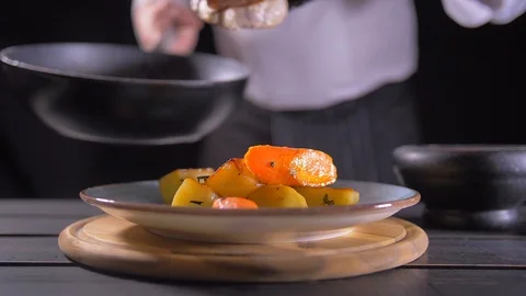 Close up of chef hand holding hot pan and adding salt to it with other hand Stock Footage 127047748