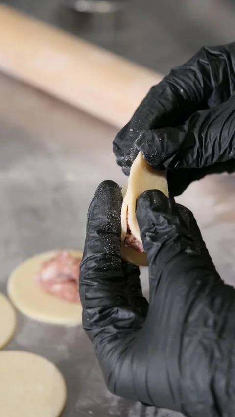 Close-up of chef hands in black gloves shaping and filling homemade meat Stock Footage 318316312
