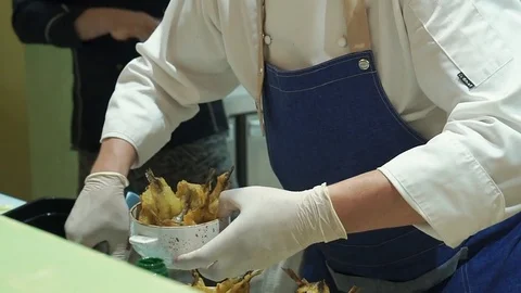 Close-up of chef hands cooking and preparing small fish in the restaurant Stock Footage 77280733