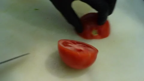 Close up of chef hands cutting a fresh red tomato on a board Stock Footage 340080576