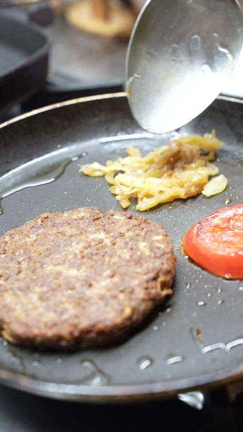 Close-up of chef hands frying plant-based patty for vegan burger Stock Footage 341520477
