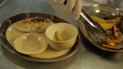 Close-up of chef hands getting potato with carrots as a garnish Stock Footage 78486973