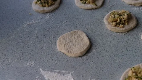 Close-up of chef hands lay meat filling on a circle of dough Stock Footage 130656768