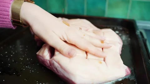 Close-up of chef hands massaging soy sauce over scored pork belly on a baking 스톡 동영상 328850803
