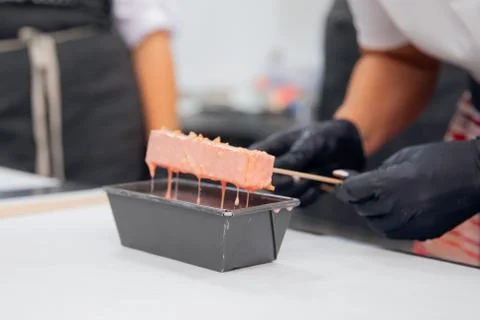 Close-up of chef hands preparing cakes and desserts covered with chocolate glaze Stock Photos