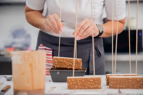 Close-up of chef hands preparing cakes and desserts covered with chocolate glaze Foto stock