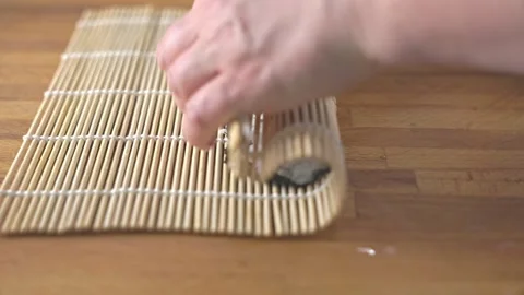 Close up of chef hands rolling sushi with salmon and rice on bamboo mat. Stock Footage 337486578