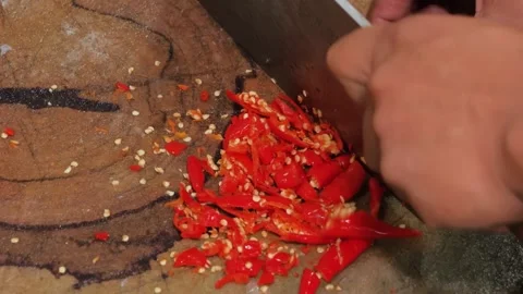 Close-up of Chef Hands Slicing Fresh Red Chili Peppers on Wooden Cutting Board Stock-Footage 344219718