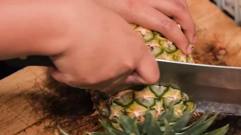Close-Up of Chef Hands Slicing Fresh Pineapple on Wooden Cutting Board Stock Footage 345645265