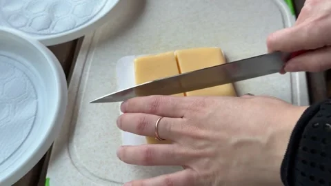 Close up of chef hands slicing yellow cheese wooden board Stock Footage 345723546