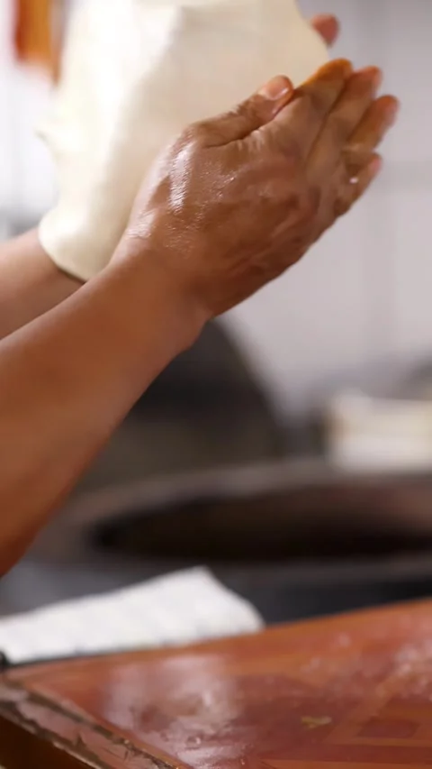 Close Up of Chef Hands Stretching and Flipping Roti Dough Stock Footage 339871046