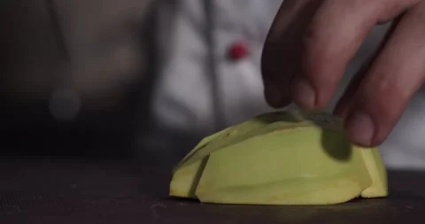 Close up of a chef with the kitchen knife cutting an avocado Stock Footage 136355873