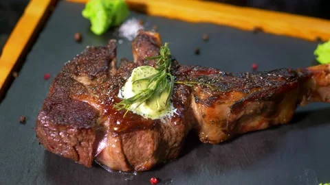 Close-up of the chef in the kitchen of the restaurant, preparing a steak for Stock Footage 179701032