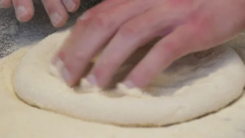 Close-up of a chef kneading pizza dough on a table in a professional kitchen. Stock Footage 308000656