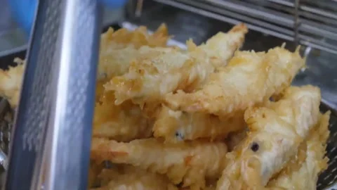 Close-Up of Chef Lifting Golden Crispy Shrimp Tempura From Deep Fryer in Wire Me Video stock 343027373