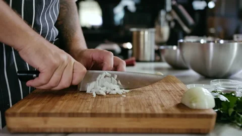 Close-up Chef Man Hands Cut Onion into Slices with Knife on Cutting Board Stock Footage 142800838