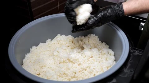 Close-up of a chef mixing sushi rice in a large bowl in a restaurant kitchen. Stock Footage 346442936