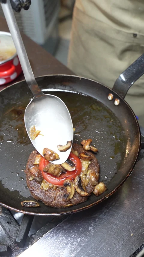 Close-up of chef placing top bun on gourmet vegan burger in kitchen Stock Footage 340368067