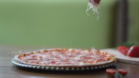 Close-up of chef pouring cheese on pizza at commercial restaurant kitchen Video stock 111854331