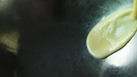 Close-up of a chef pouring egg mixture into a metal bowl for whipping in a mixer Stock Footage 131096577