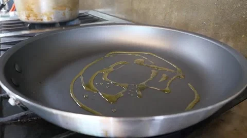 Close-up of Chef Pouring Golden Olive Oil into a Frying Pan for Authentic Italia Stock Footage 337676594