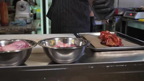 Close-up of the chef pouring sauce over pork ribs before baking in the oven. Stock Footage 345131891