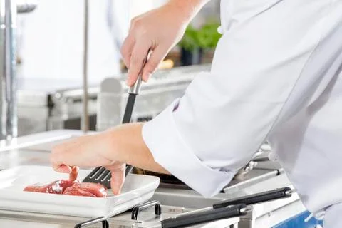 Close-up of a chef prepares beef steak in pan at the kitchen Stock Photos