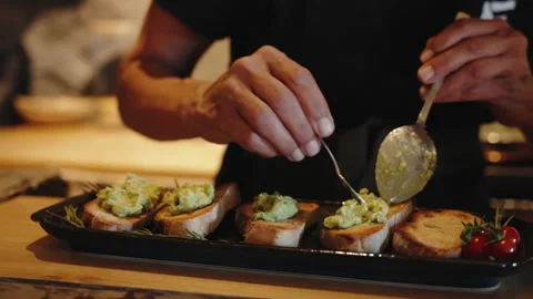 Close-up of a Chef Preparing Avocado Bruschetta on Toasted Bread with Cherry Vídeo Stock 334665481