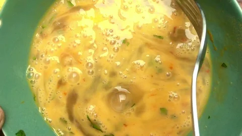 Close up chef preparing eggs in a bowl for omelette - 25 s Stock Footage 128014376