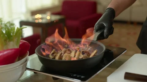 Close-up of a Chef Preparing Flambe Style Dish on a Pan. Open Flames Stock Footage 137318892