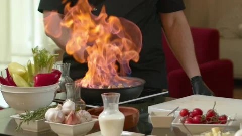 Close-up of a Chef Preparing Flambe Style Dish on a Pan. Open Flames Stock Footage 137318943