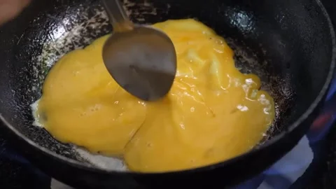 Close-up of Chef Preparing Fluffy Scrambled Eggs in a Hot Pan Stock Footage 338211891