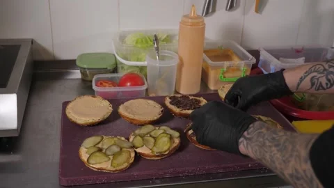 A close-up of the chef preparing four burgers in the kitchen of the restaurant. Stock Footage 342702573