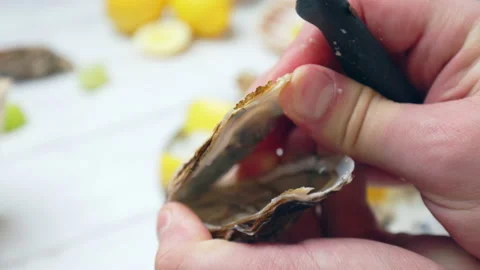 Close-up Chef preparing fresh Oysters from crushed ice by opening with a knife. Stock Footage 146319296