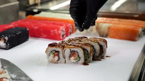 Close-up of a chef preparing sushi, sprinkling sesame seeds. Stock Footage 322215784