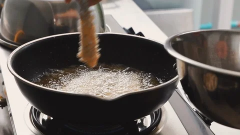 Close up of chef put shrimp into boiling oil to cook deep fried shrimp Stock Footage 113383221
