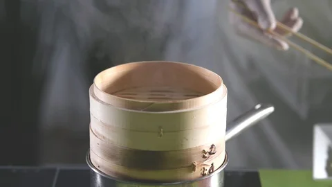 Close-up of a chef putting freshly made dumplings into a traditional bamboo s Stock Footage 123884764