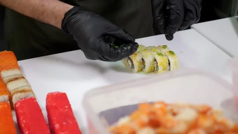 Close-up of a chef putting green chili peppers on sliced sushi in a restaurant. Stock Footage 321814787