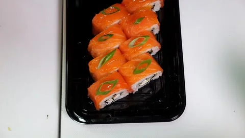 Close-up of a chef putting green onions on sliced sushi in a restaurant. Stock Footage 323363025