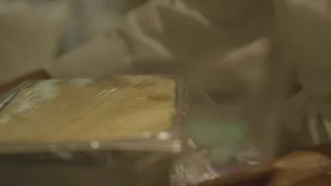 Close-up chef putting plastic wrap on dough in metal box 库存影片 336173838