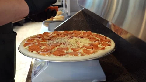 Close-up of a chef putting sausage on a pizza before baking in the kitchen. Stock Footage 341550658