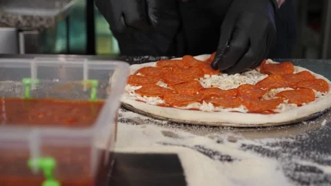 Close-up of the chef putting the sausage on the pizza dough. Pepperoni pizza. Stock Footage 346442422