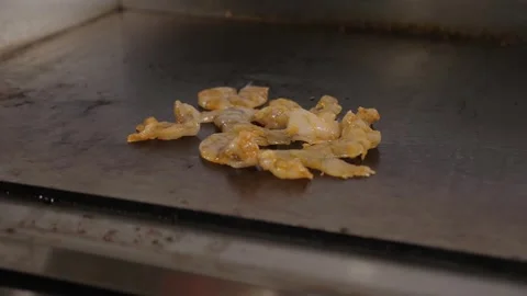 A close-up of the chef putting shrimp on an industrial hot plate for frying. Stock Footage 345132541